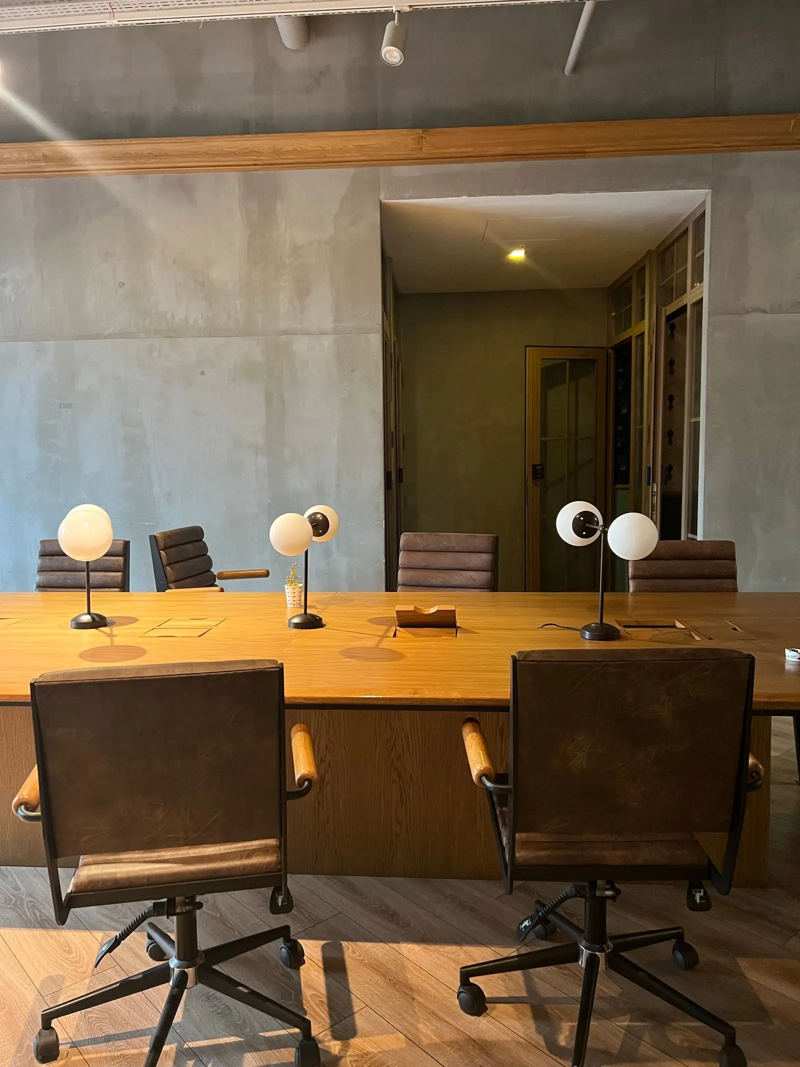 Besprechungsraum der Kanzlei mit Holztisch und Sichtbeton